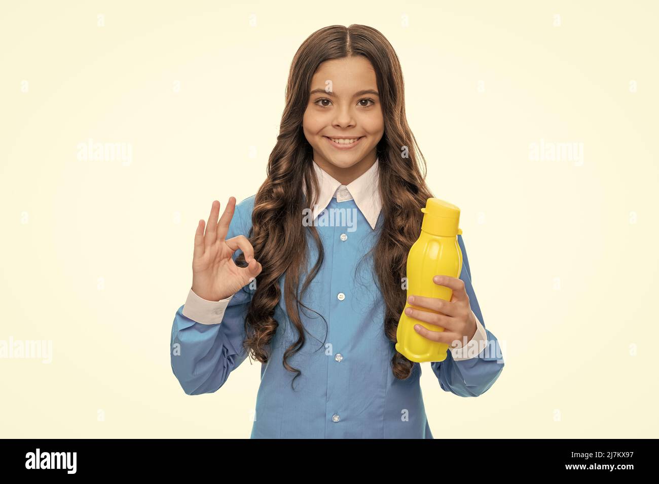 Happy ragazza mostra OK segno tenendo giallo bottiglia di plastica acqua potabile, abitudini sane Foto Stock