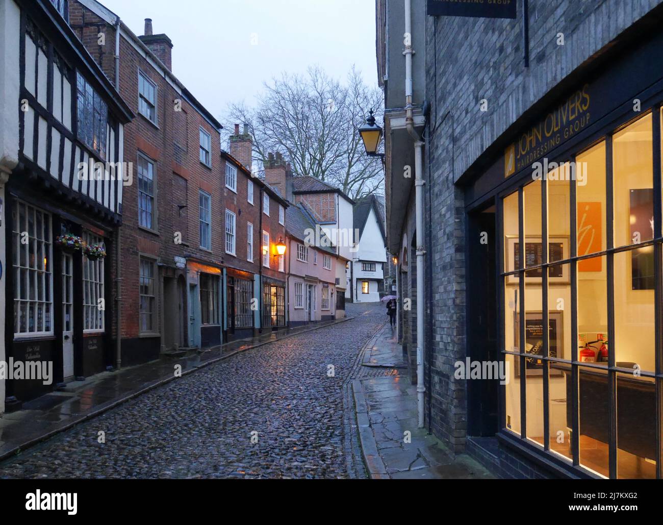 Elm Hill al tramonto con negozi illuminati all'interno e lanterne illuminate, Norwich, Norfolk, Inghilterra, Regno Unito Foto Stock