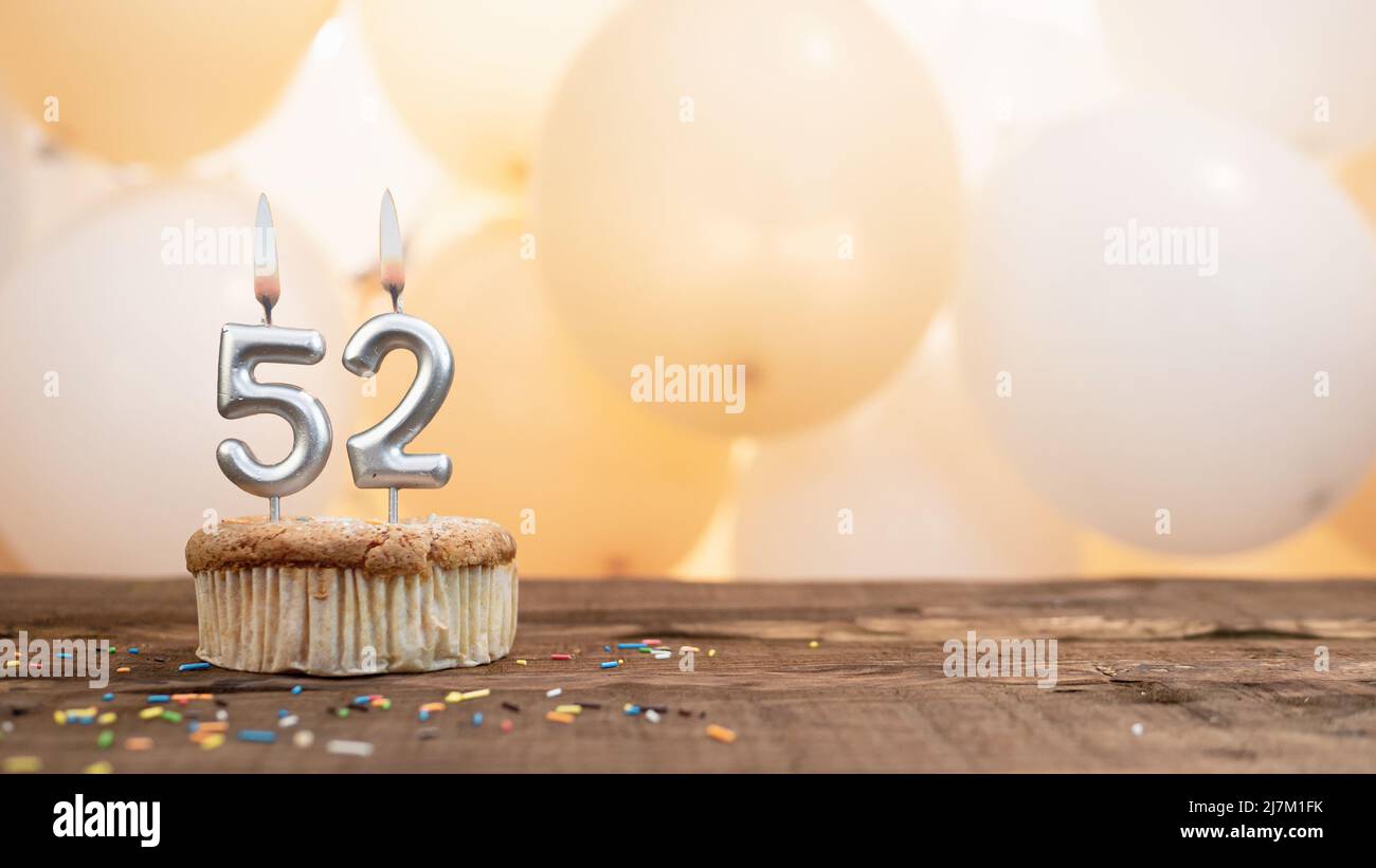 Buon compleanno carta con una candela in un cupcake sullo sfondo di palloncini. Spazio copia buon compleanno con cupcake cifra Foto Stock