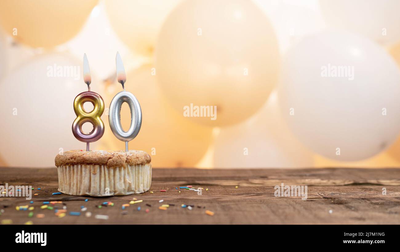 Buon compleanno carta con una candela in un cupcake sullo sfondo di palloncini. Spazio copia buon compleanno con cupcake cifra Foto Stock