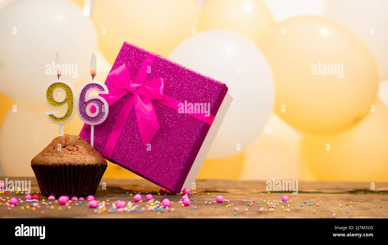 Buon compleanno con scatola regalo rosa per bambina. Bella tessera di compleanno con un cupcake e una candela che brucia Foto Stock