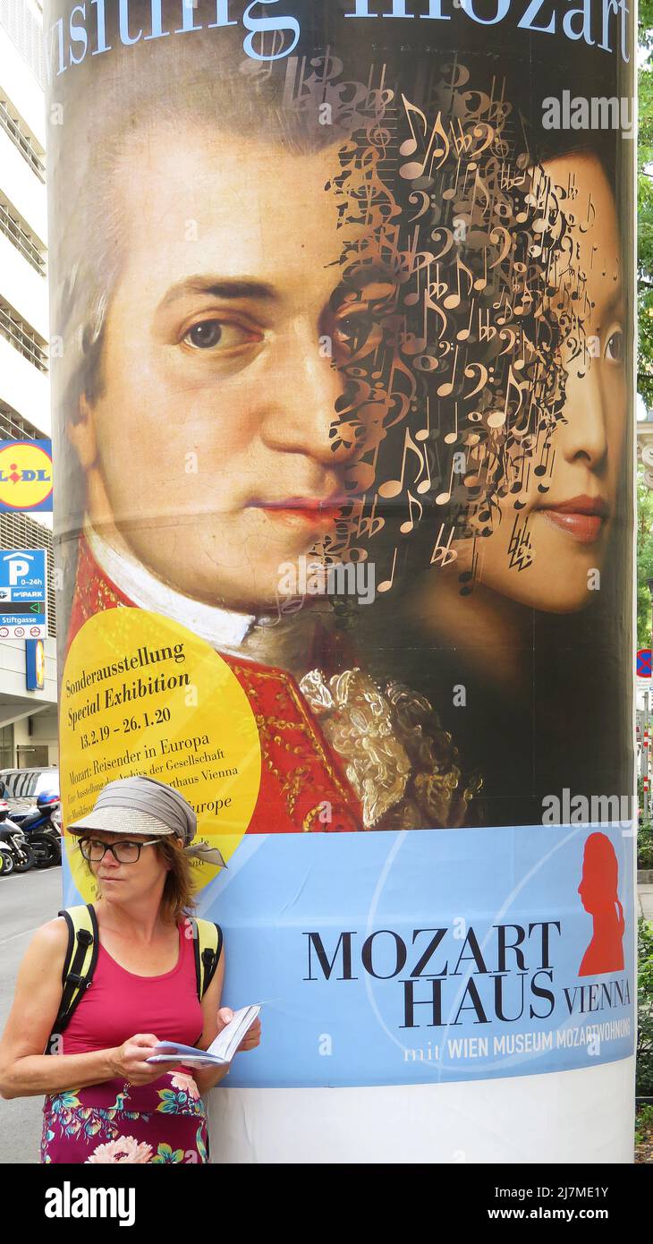 Austria, turista in piedi di fronte a un poster pubblicitario della Casa Mozart a Vienna Foto Stock