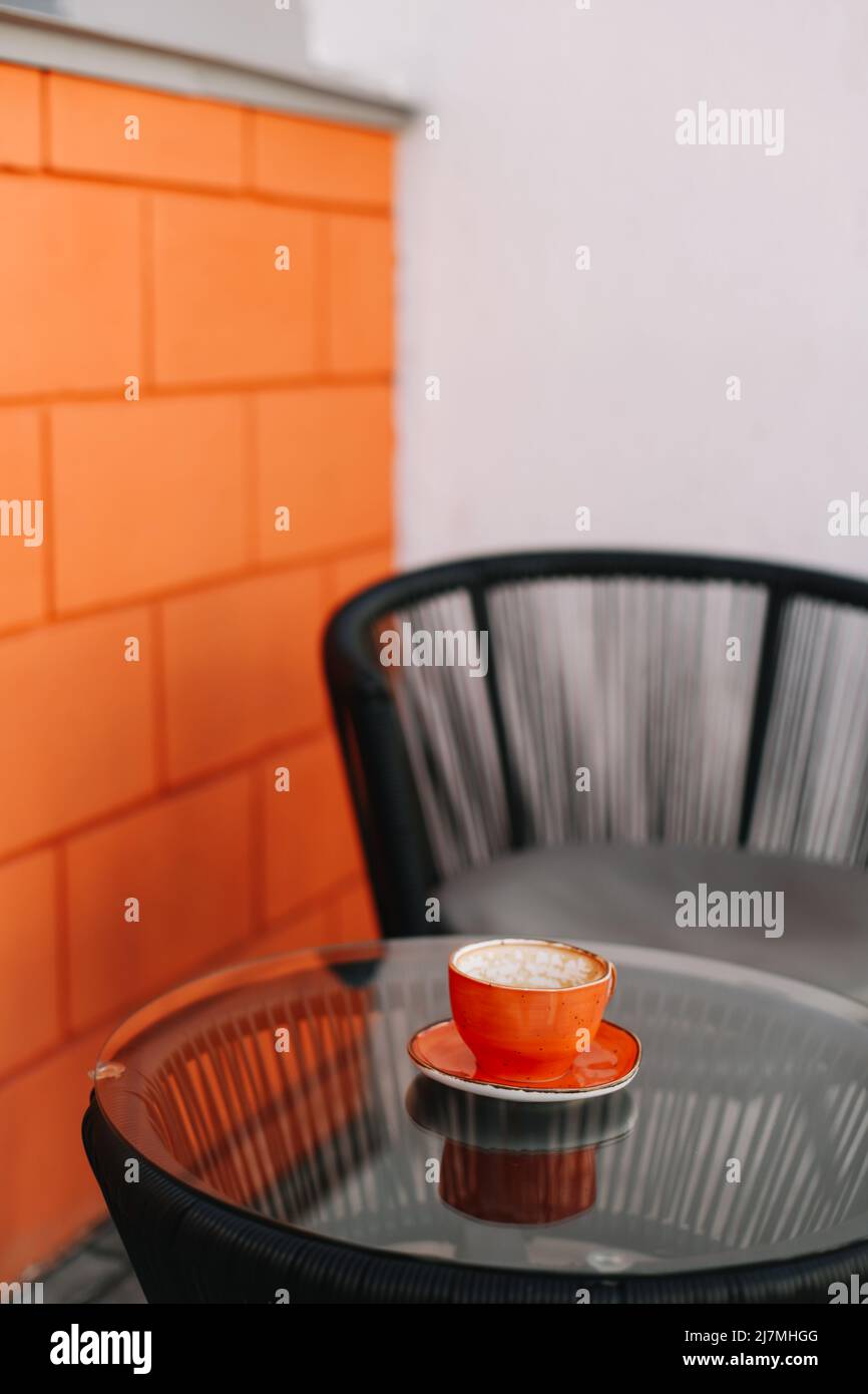 una tazza di caffè su un tavolo di vetro al mattino. Foto Stock