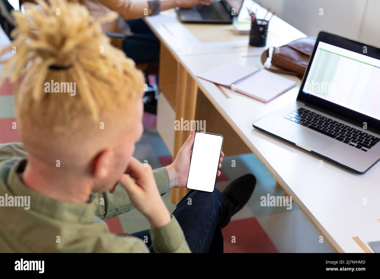 Albino afroamericano medio uomo d'affari adulto che utilizza smartphone con schermo vuoto in ufficio Foto Stock