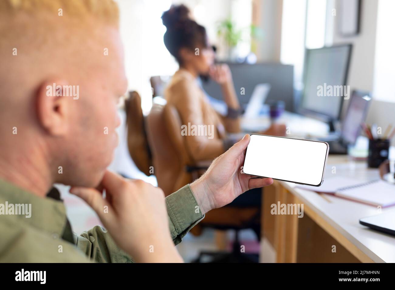 Primo piano di un uomo d'affari albino afroamericano medio adulto utilizzando smartphone con schermo vuoto Foto Stock