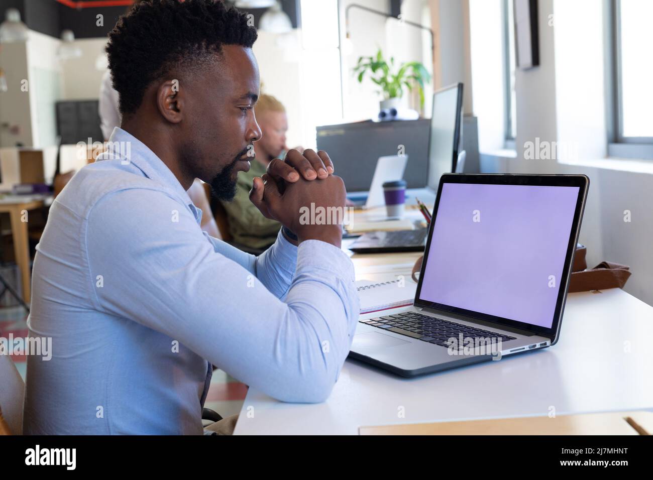 Uomo d'affari africano americano medio adulto con le mani afflitto guardando il laptop con schermo vuoto Foto Stock