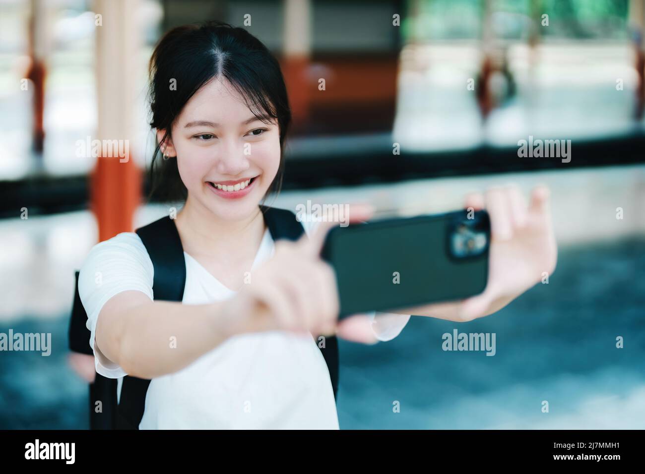 Estate, relax, vacanza, viaggio, ritratto di bella ragazza asiatica utilizzando lo smartphone mobile prendere una foto selfie faccia te alla stazione ferroviaria Foto Stock
