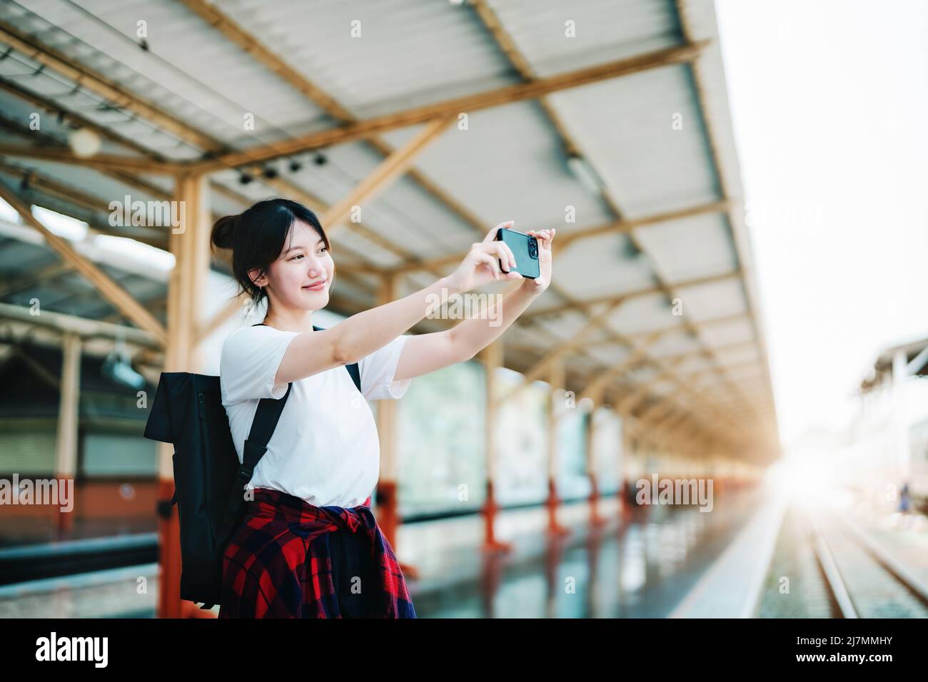 Estate, relax, vacanza, viaggio, ritratto di bella ragazza asiatica utilizzando lo smartphone mobile prendere una foto selfie faccia te alla stazione ferroviaria Foto Stock