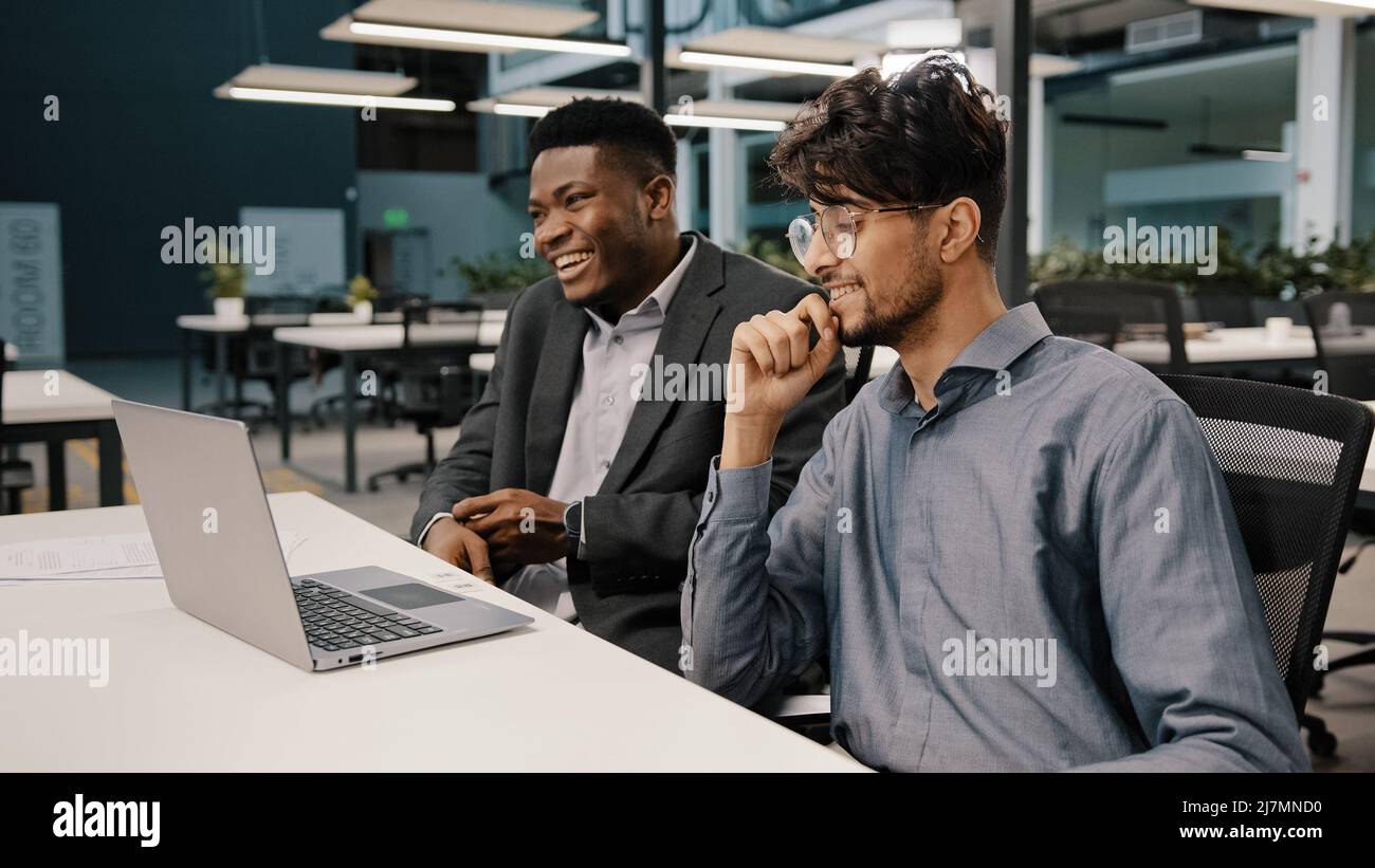 Vista laterale diversi colleghi felici uomini d'affari africani parlare con lavoratore dipendente arabo divertirsi insieme piacevole conversazione multirazziale Foto Stock