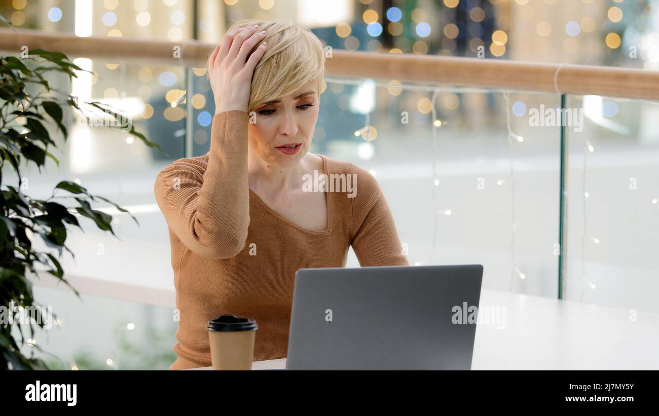 Caucasica mezza età matura 40s business donna con laptop problemi di lavoro con pagamento computer guasto errore perdere sensazione frustrato cattive notizie Foto Stock