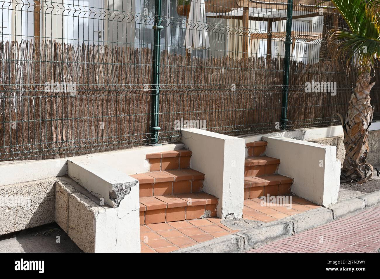 Una linea di proprietà con gradini ora non in uso, in quanto portano a una recinzione su un passaggio pedonale a Tenerife, Spagna, passi da nessuna parte Foto Stock