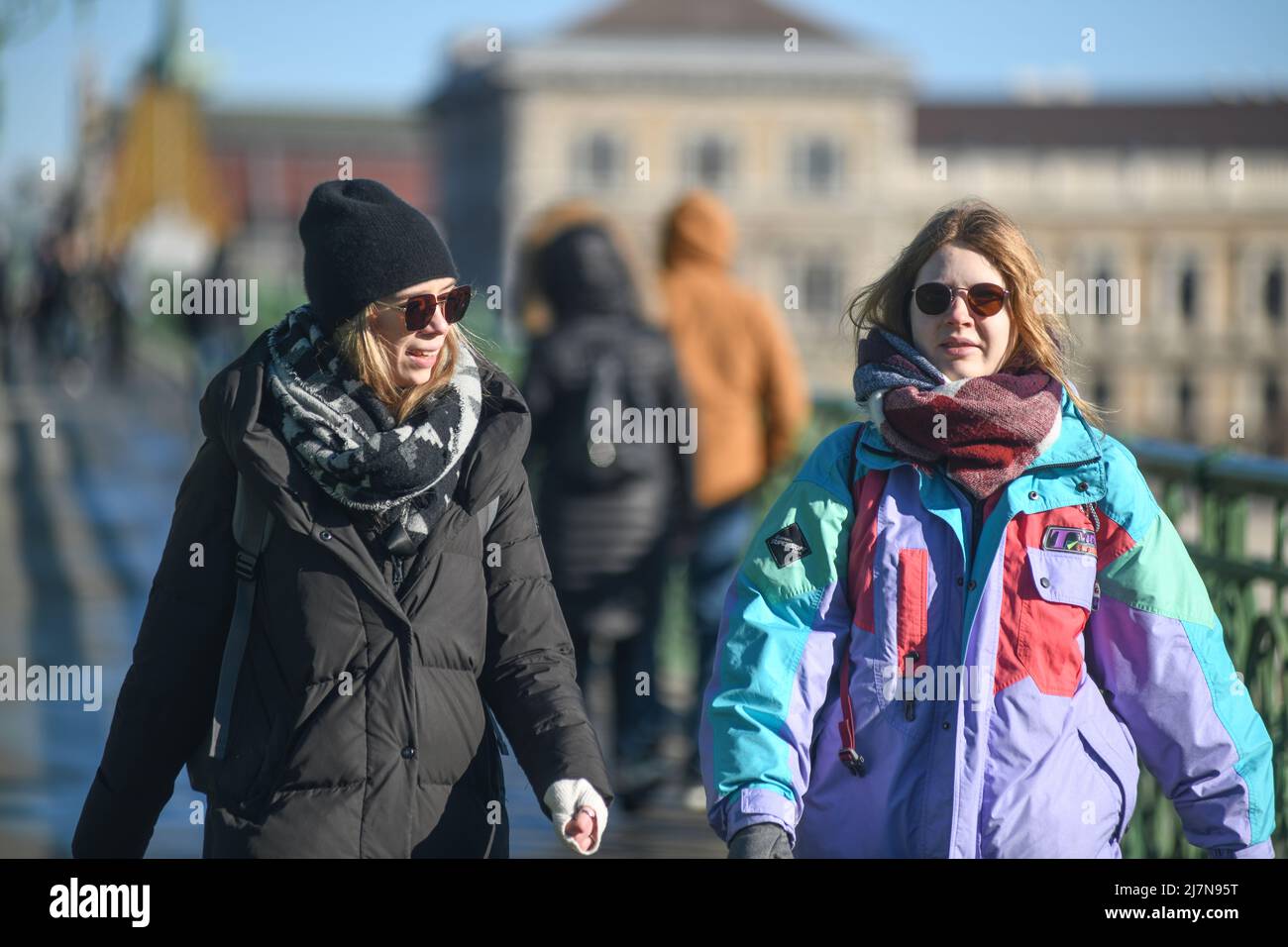Donne ungheresi che camminano attraverso il Ponte della libertà durante l'inverno. Budapest, Ungheria Foto Stock