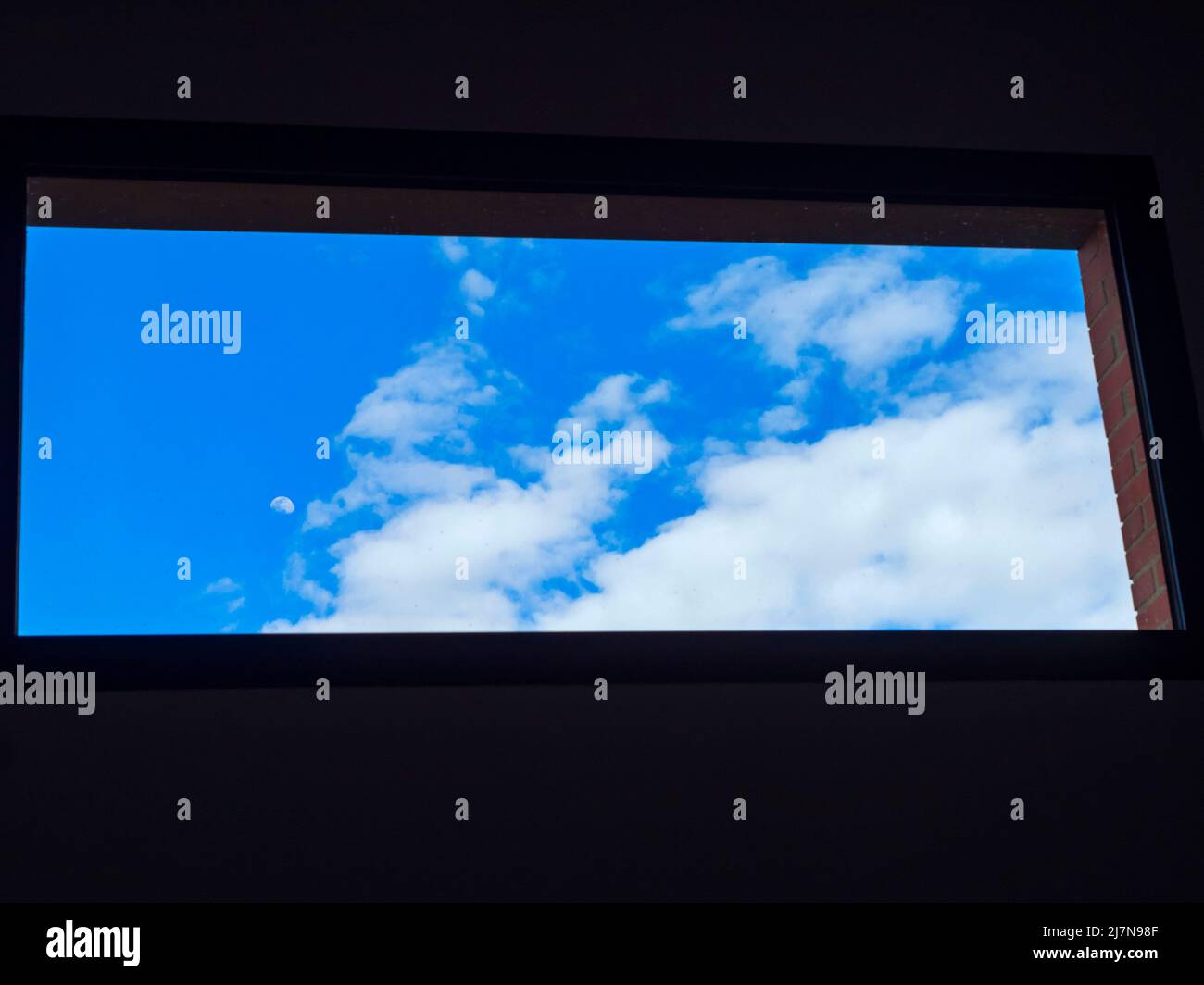 Cielo blu con nuvole attraverso una finestra Foto Stock