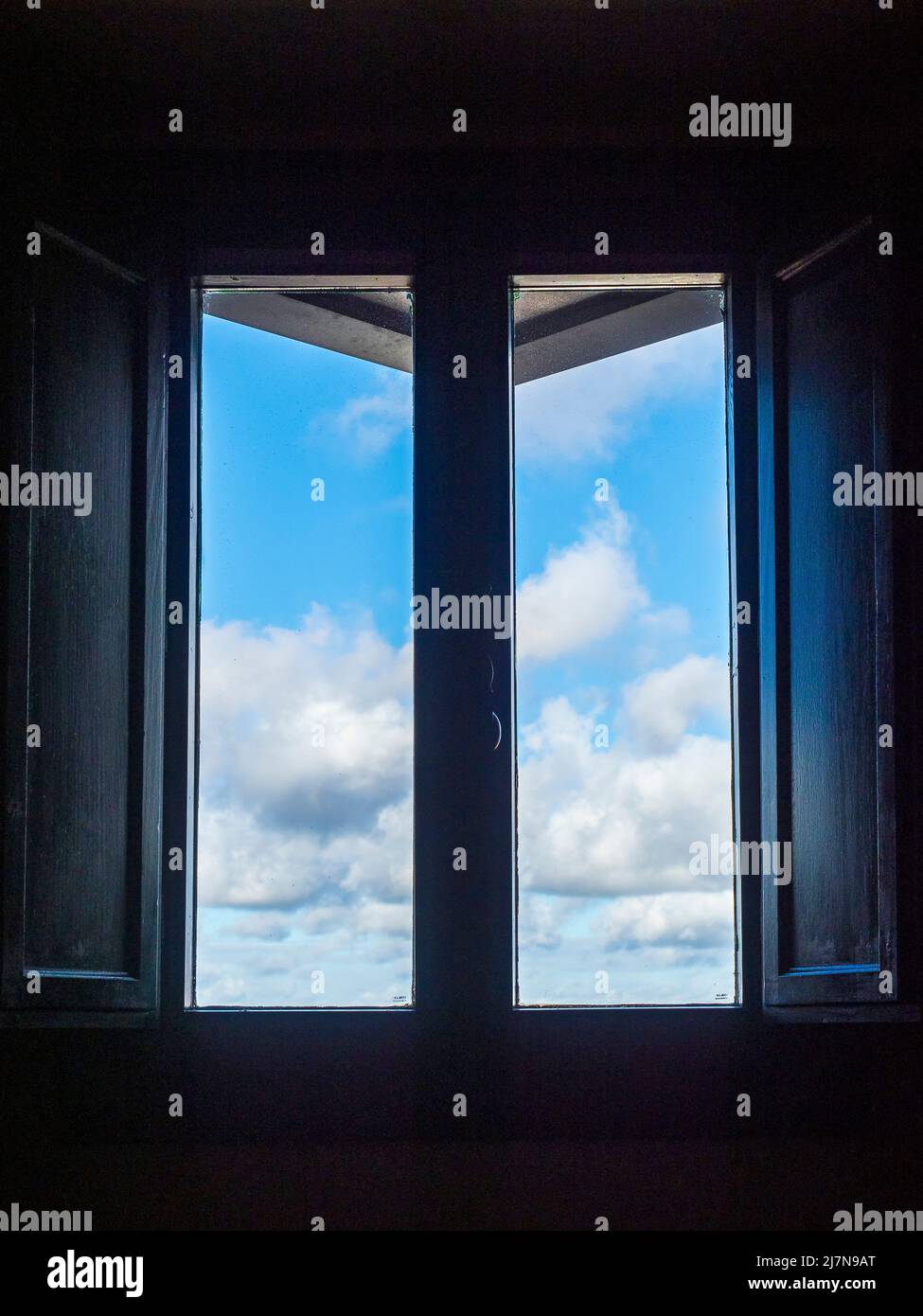 Cielo blu con nuvole attraverso una finestra Foto Stock
