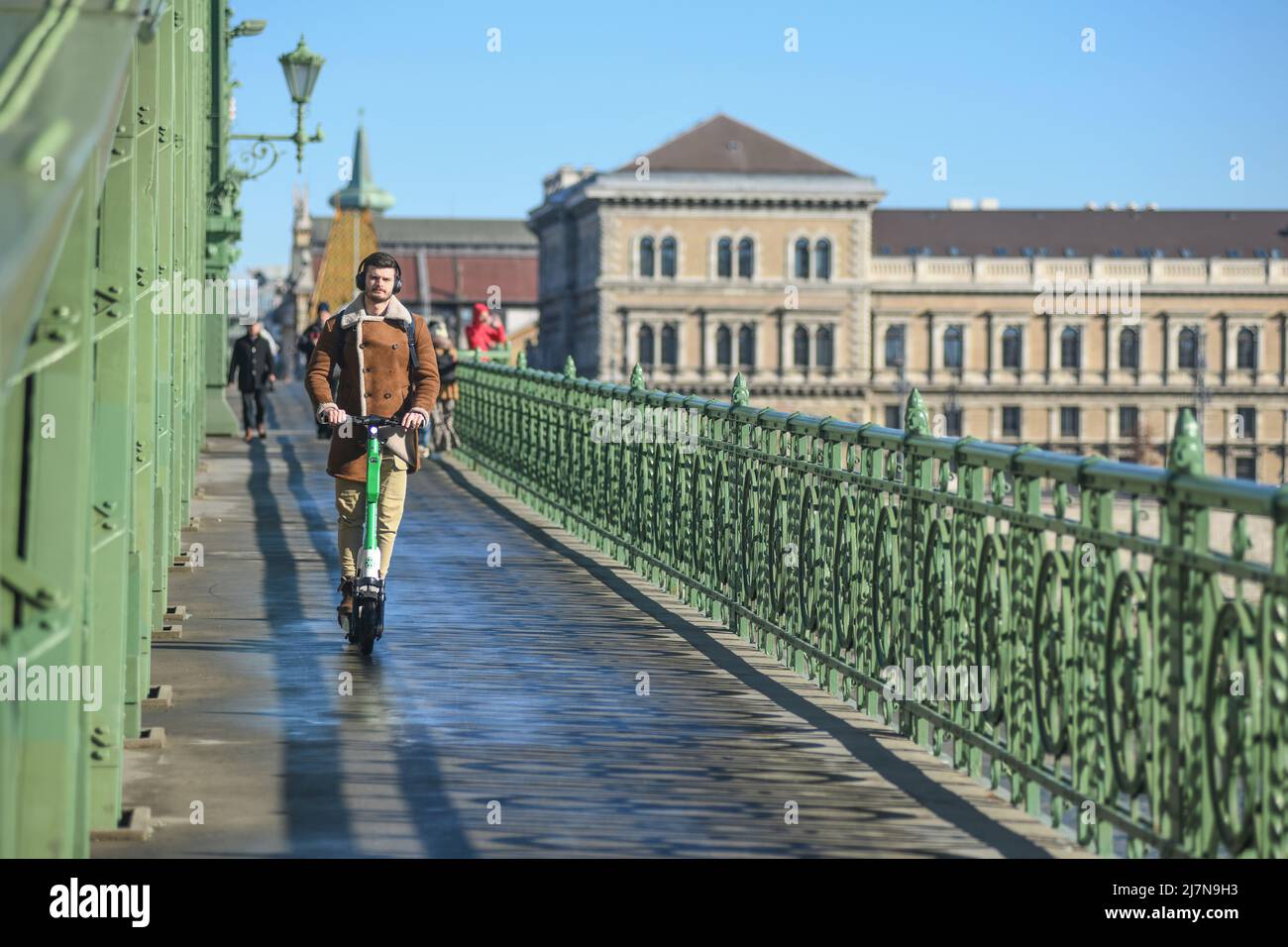 Uomo ungherese che attraversa il Ponte della libertà su uno scooter. Budapest, Ungheria Foto Stock