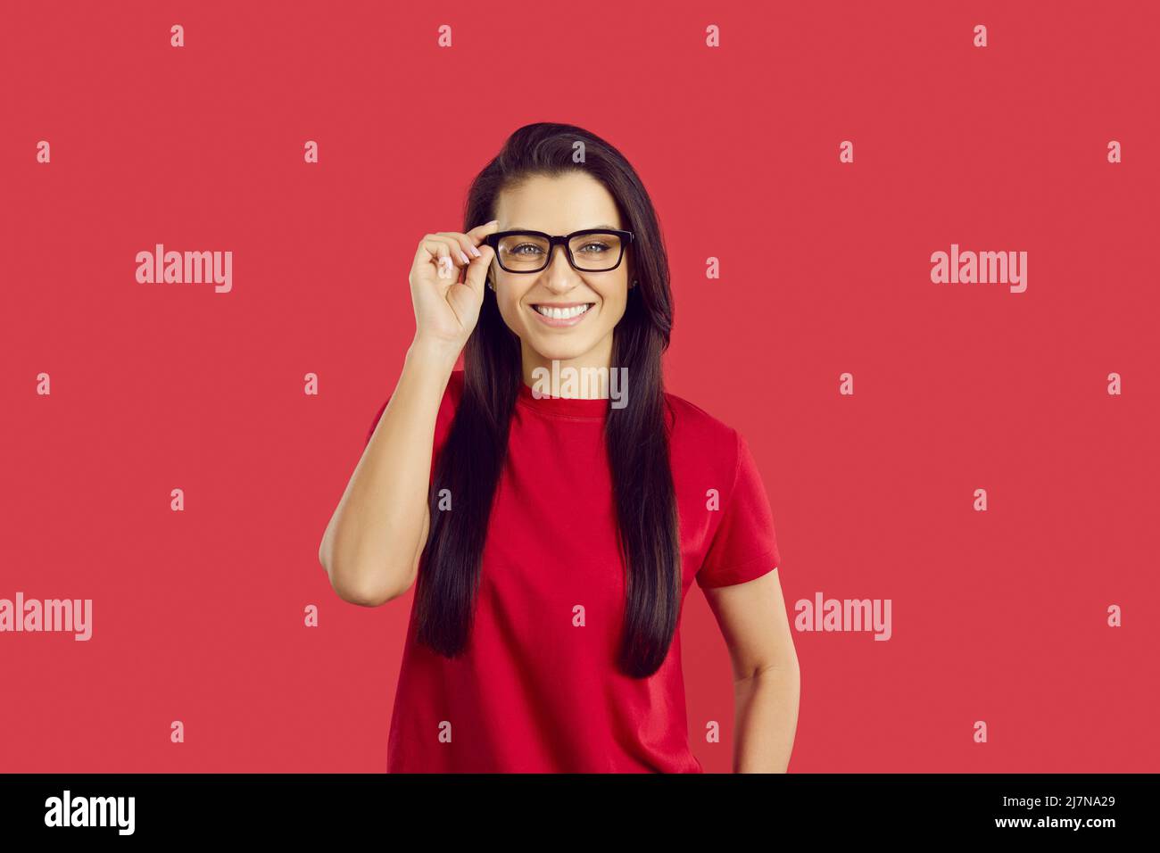 Sorridente giovane donna in occhiali per una migliore visione Foto Stock