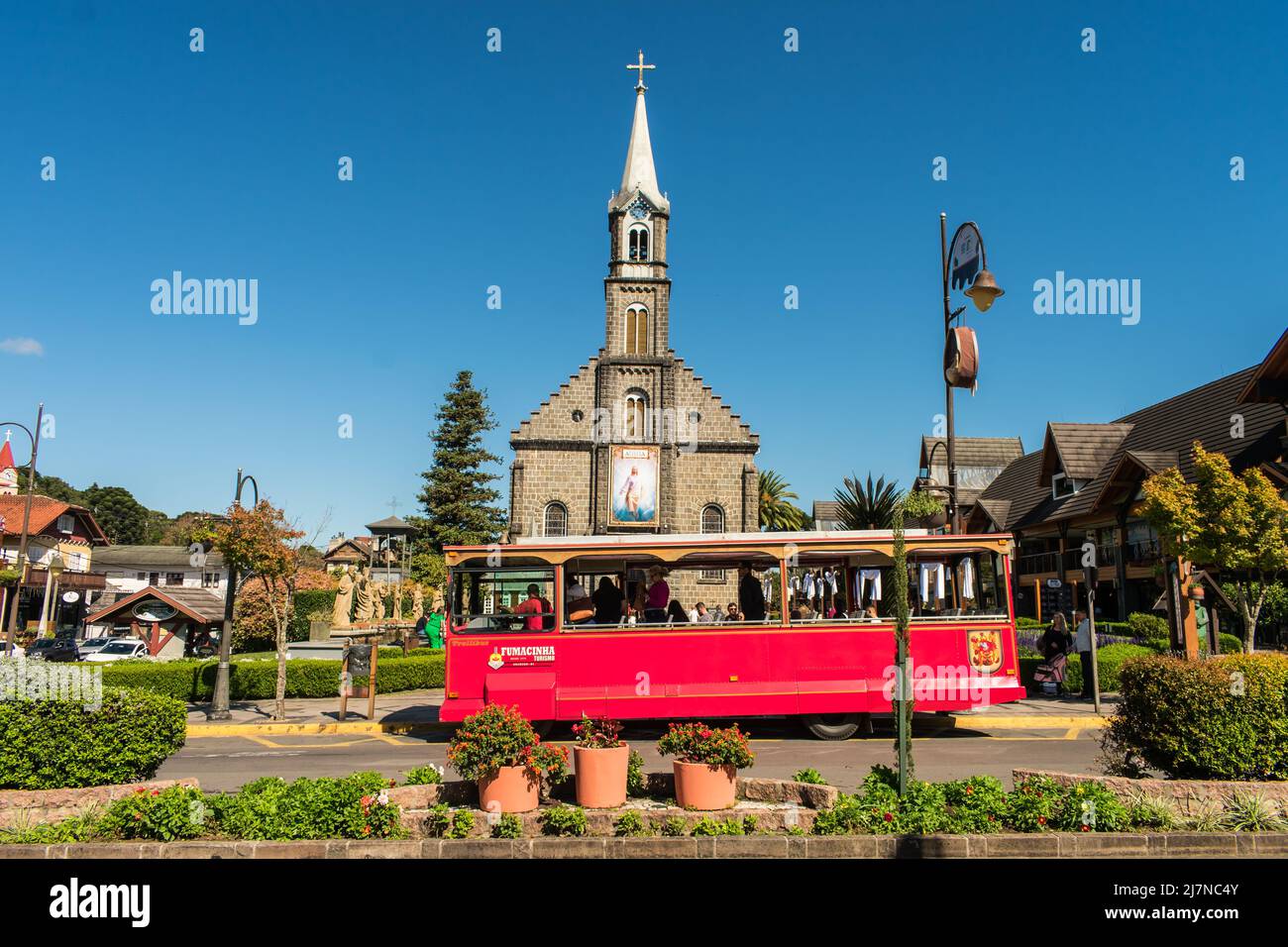 Gramado, Brasile - Circa Aprile 2022: Chiesa di San Pietro e famoso tram rosso (Fumacinha) nel centro di Gramado, Rio Grande do sul Foto Stock