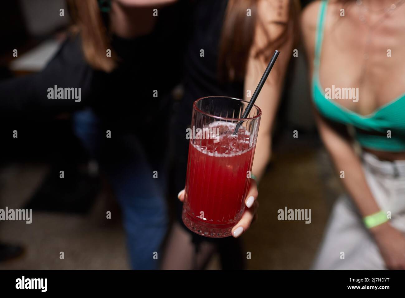 Primo piano immagine ritagliata di donna che tiene dolci cocktail gustosi limonata, elegante hipster outfit alla moda e gioielli eleganti, colori tonici, atmosfera da bar Foto Stock