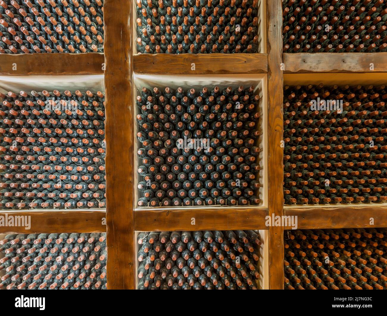 Vecchie bottiglie di vino che maturano in una cantina volta Foto Stock