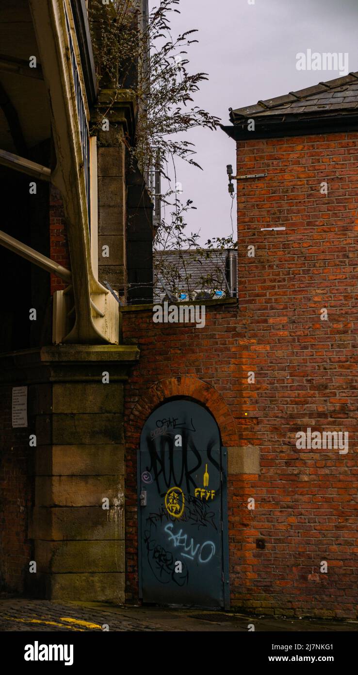 Colpo astratto di una fuga di fuoco con graffiti su di esso, oscurato da un ponte viadotto a Deansgate, Manchester, Greater Manchester, Regno Unito. Foto Stock