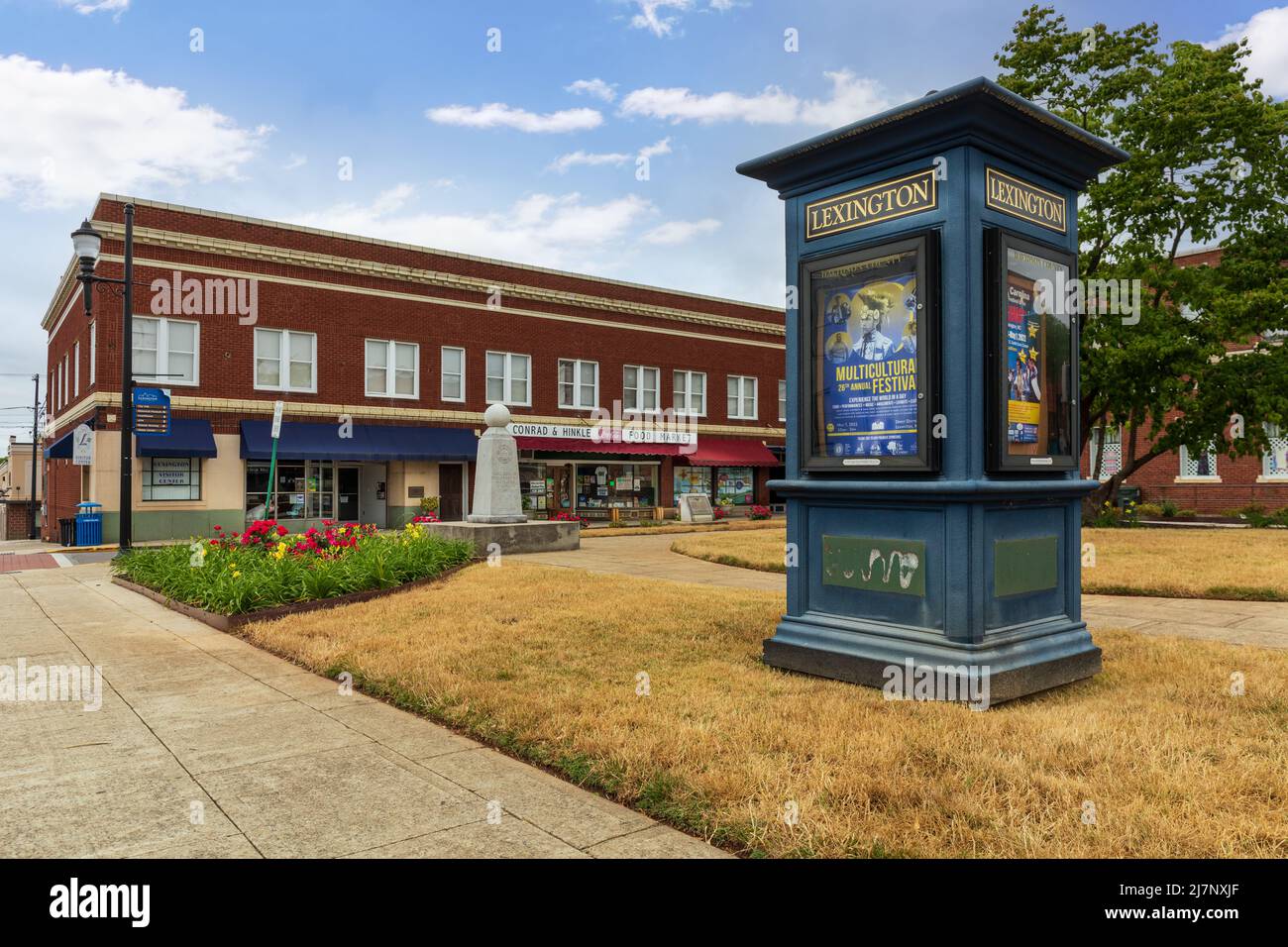 LEXINGTON, NC, USA-8 MAGGIO 2022: Chiosco che mostra poster informativi di eventi culturali set di fronte a vintage edifici e imprese in piccole com Foto Stock