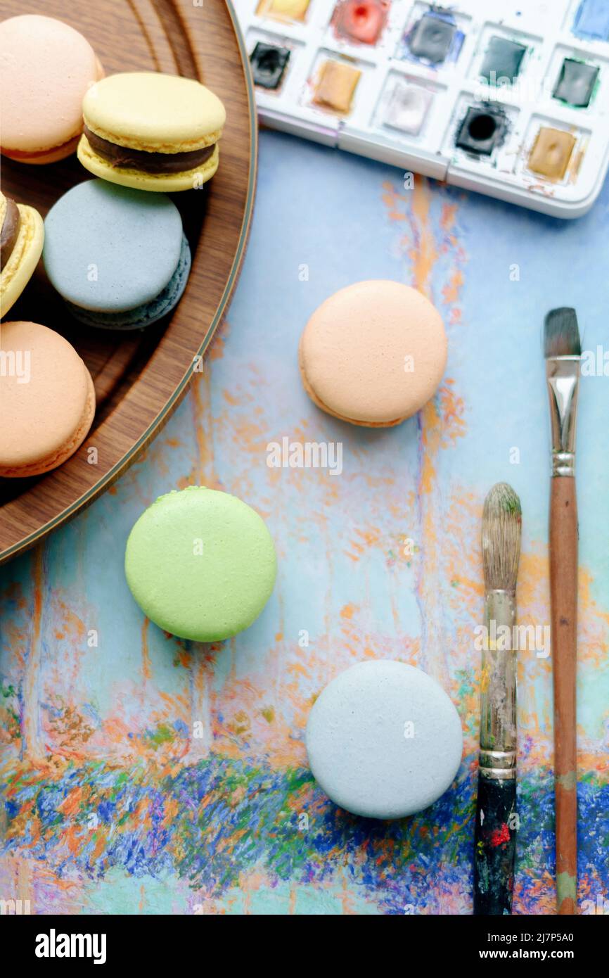 biscotti color pastello con macaron, acquerello e pennelli Foto Stock