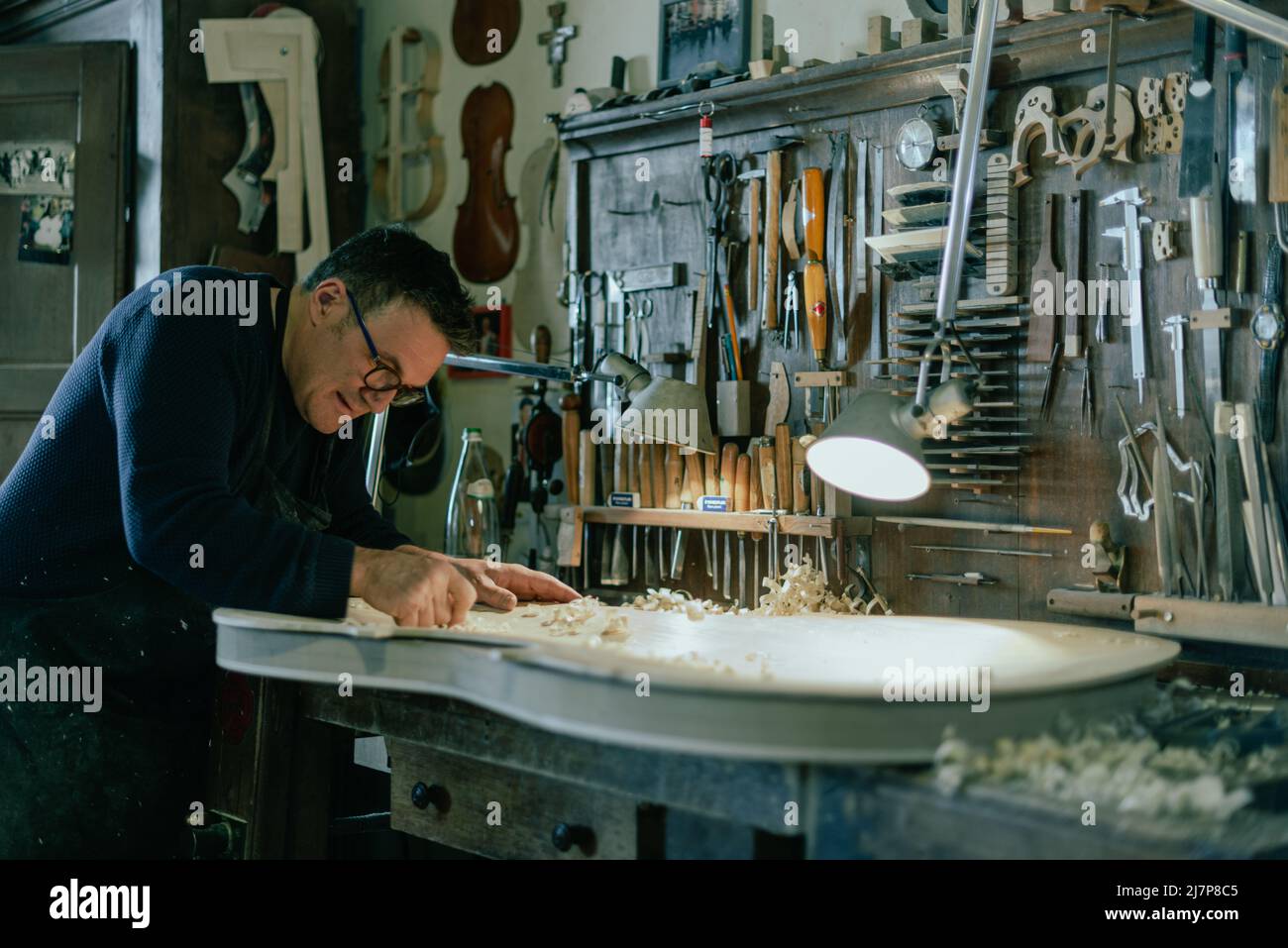 luthier lavora su un tavolo frontale a doppio basso fatto a mano nella sua officina Foto Stock