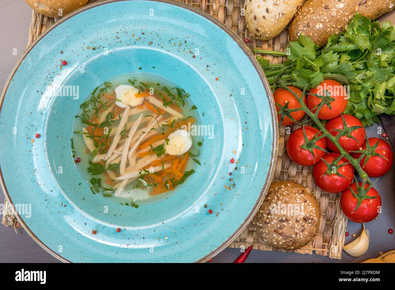 Brodo di pollo con pasta fatta in casa, carote, filetti e uova di quaglia Foto Stock