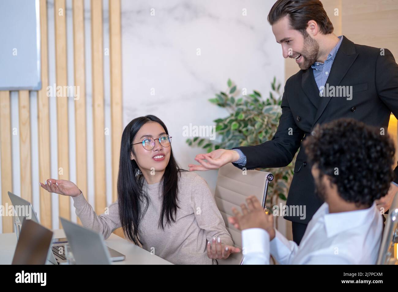 Gruppo di tre dipendenti aziendali che discutono di questioni aziendali Foto Stock