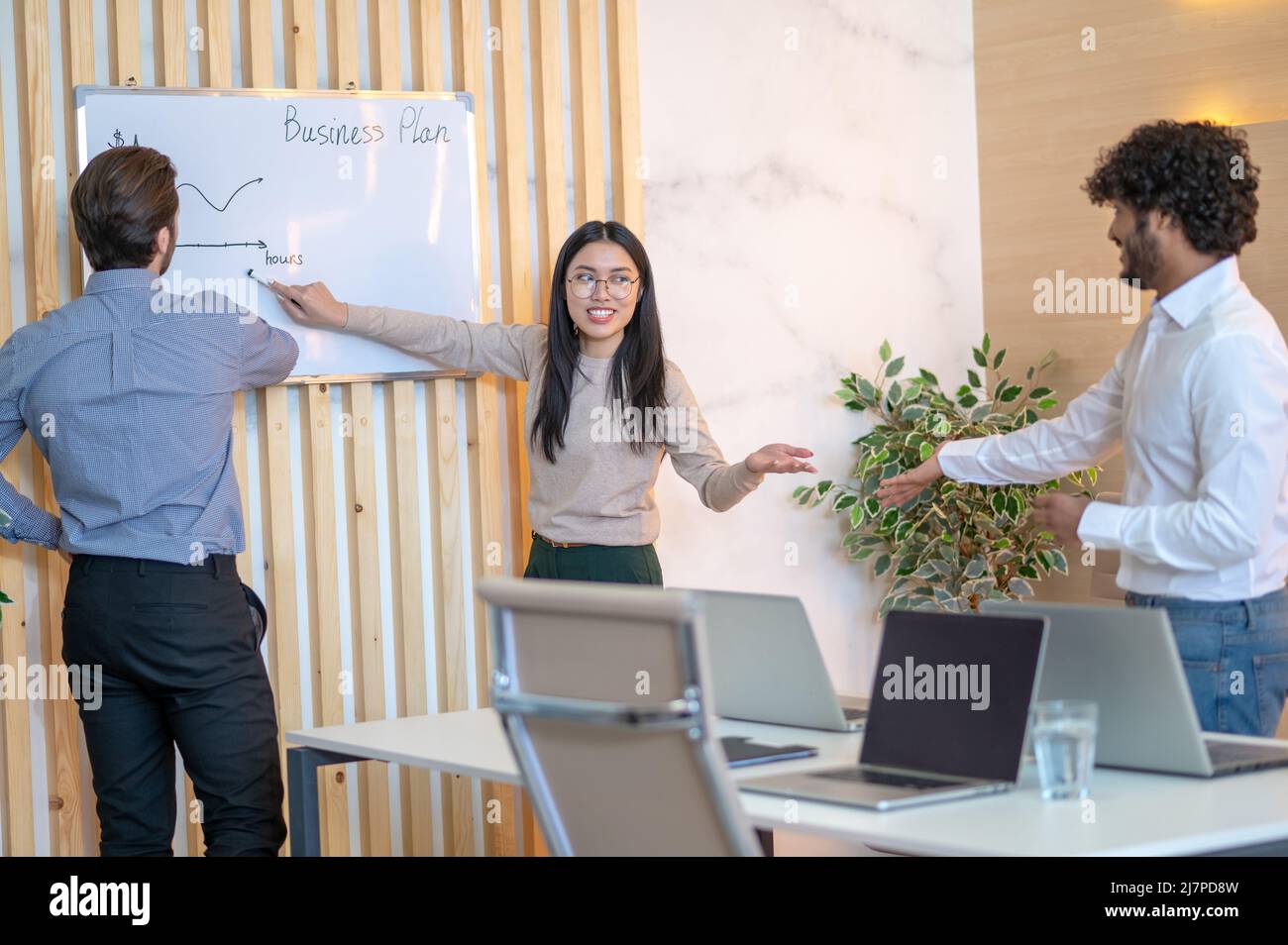 Il lavoratore dell'ufficio di joyous che discute un programma di affari con i suoi colleghe Foto Stock