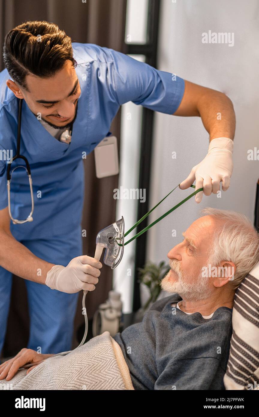 Operatore sanitario che prepara un paziente per l'ossigenazione Foto Stock