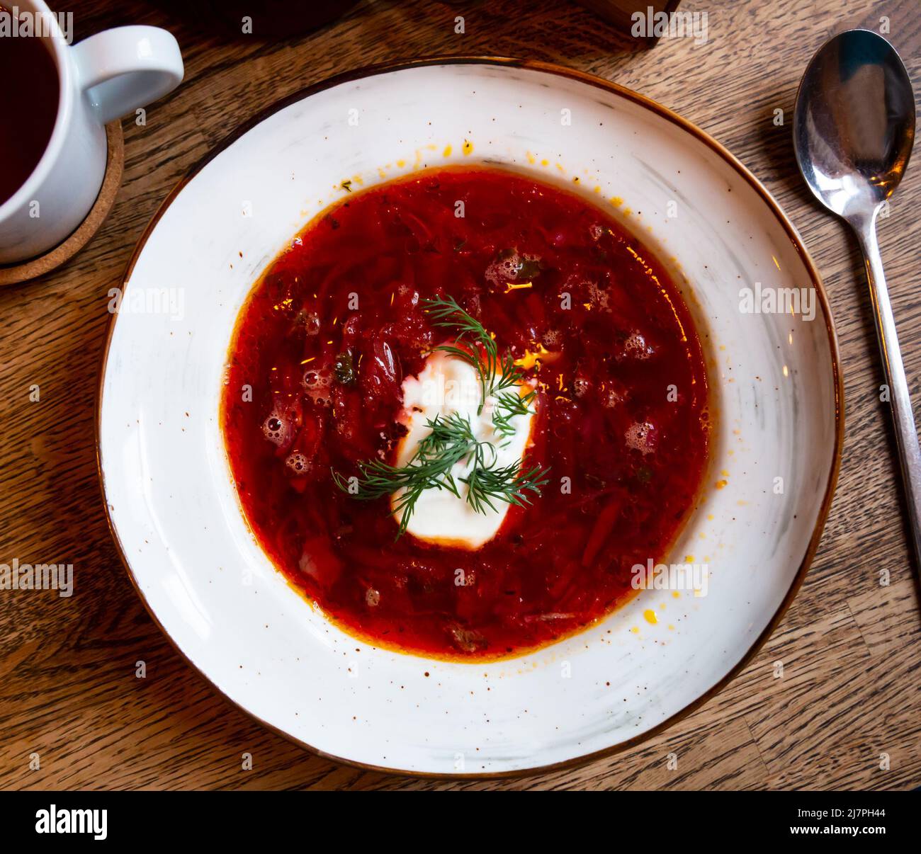 Piatto di borscht rosso guarnito con aneto e smetana Foto Stock