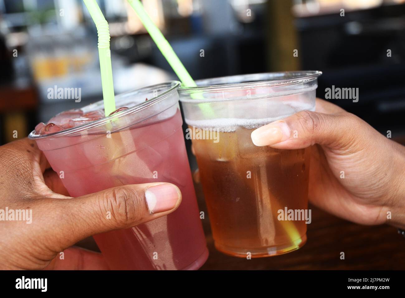 GRAZIE: Una coppia brinda un po' di bevande miste in un bar sulla spiaggia. Foto Stock