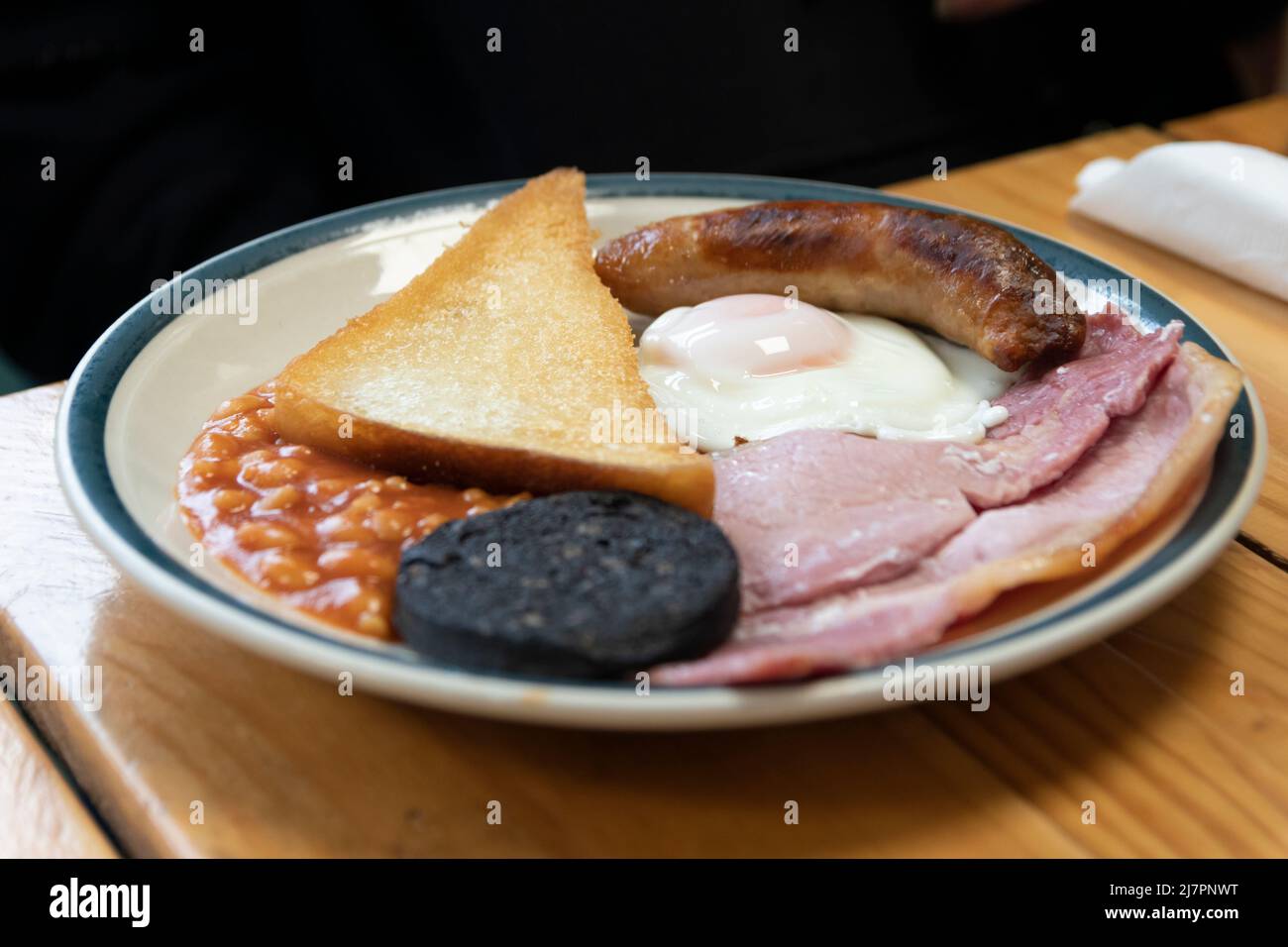 Colazione all'inglese completa, conosciuta anche come "friggitrice", composta da uova, salsiccia, pancetta, fagioli, toast, e pudding nero. Foto Stock