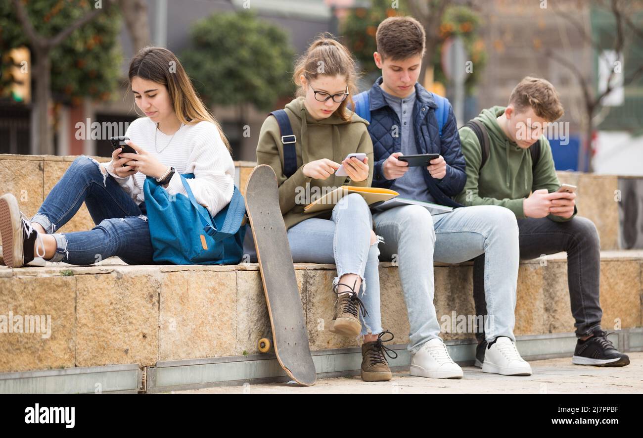 Gruppo di ragazzi che utilizzano gli smartphone all'aperto Foto Stock