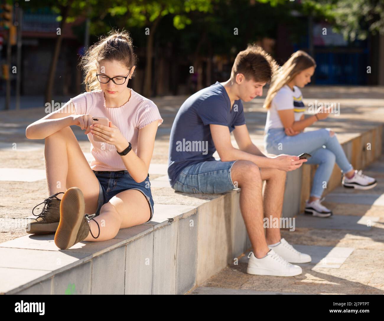 Adolescenti con telefoni assorbiti nella comunicazione online Foto Stock