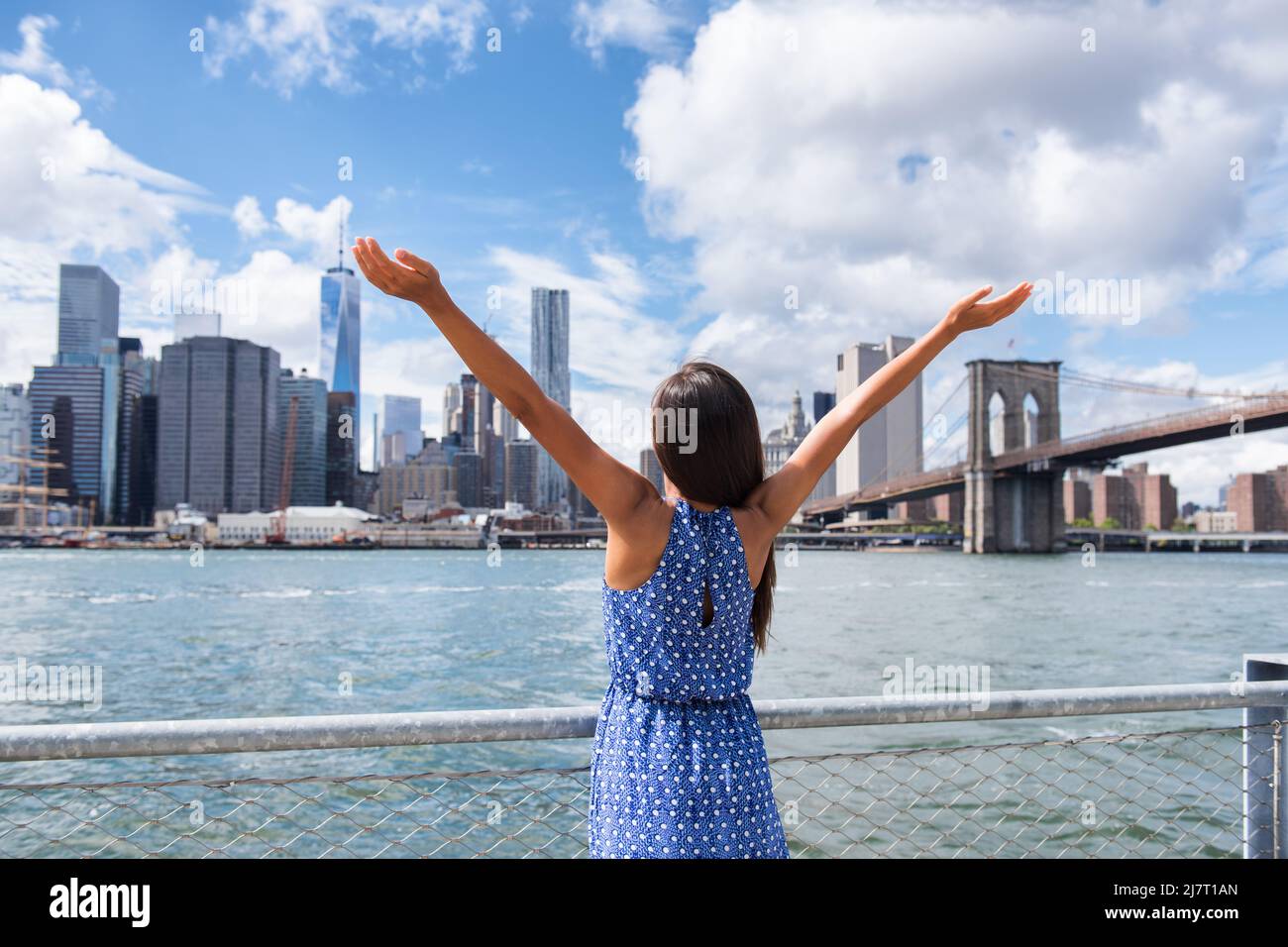 Successo nella carriera di affari a New York. Aspirazionale felice donna libera allietato da New York City skyline urbano con le braccia sollevate nel cielo. Obiettivo Foto Stock