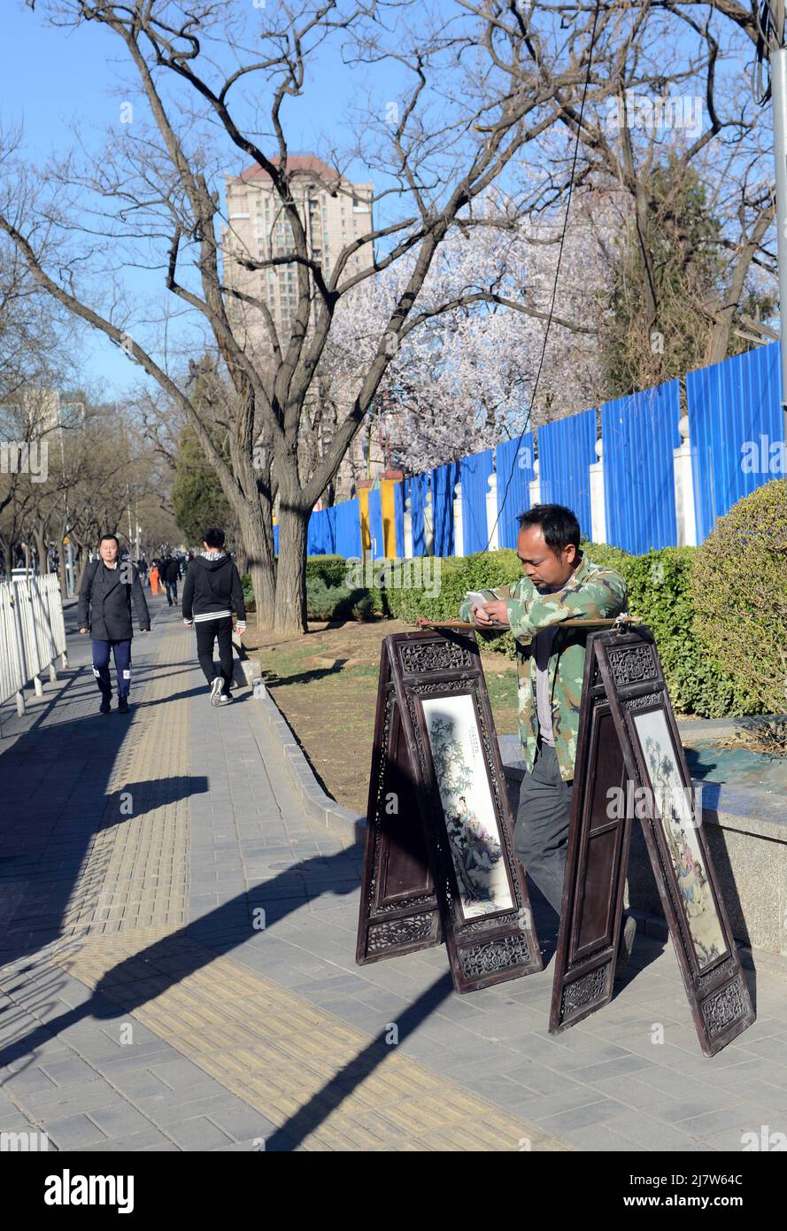 Un artista cinese che vende i suoi dipinti per strada a Pechino, Cina. Foto Stock