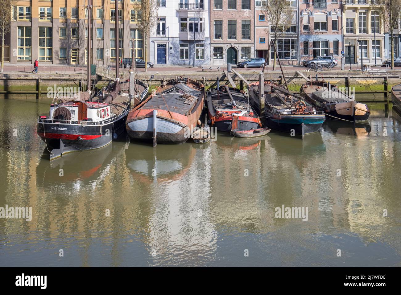 vecchie chiatte e barche in funzione in uno dei vecchi porti di rotterdam olanda Foto Stock
