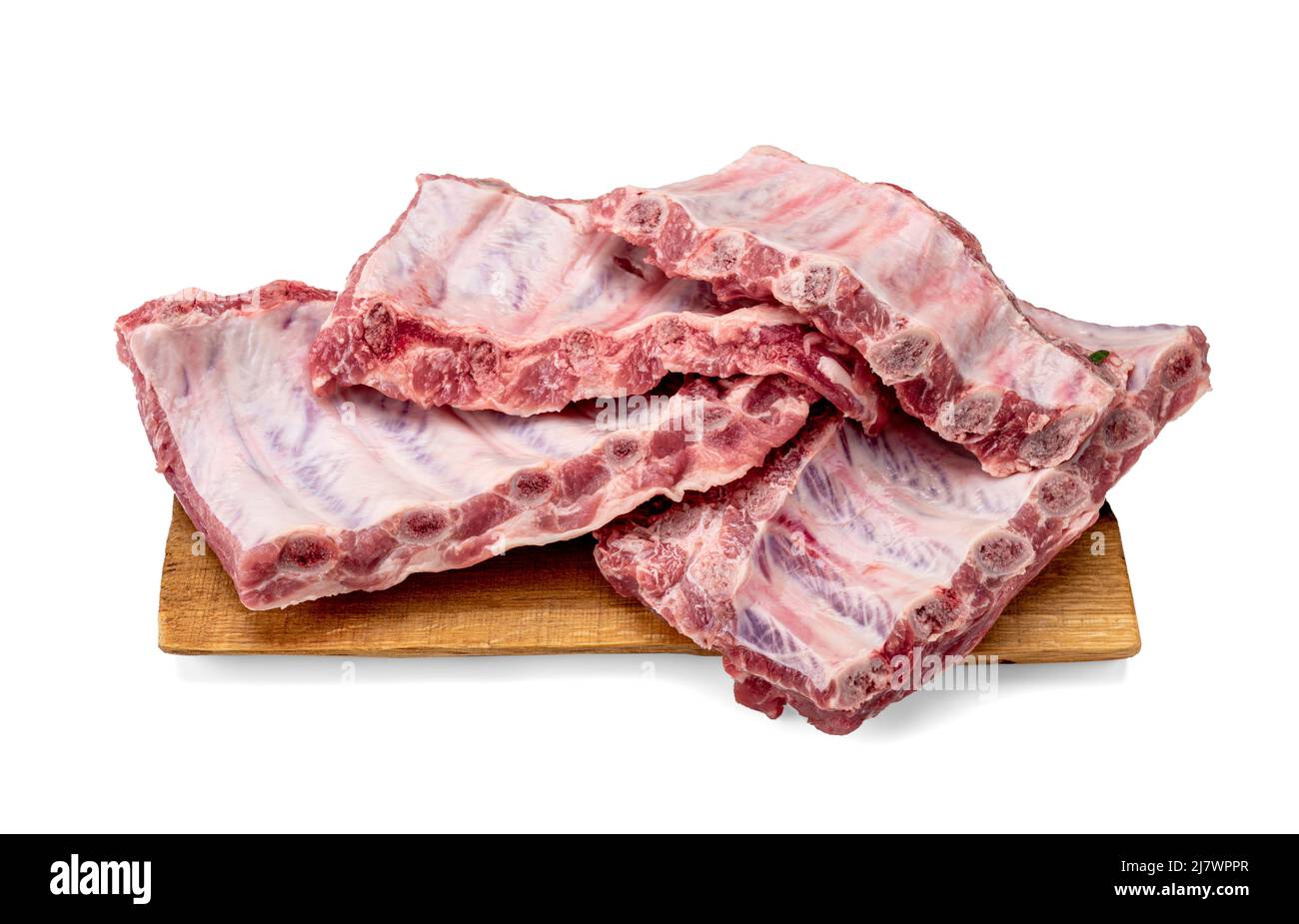 pezzi di costolette di maiale isolate su fondo bianco a bordo. Rack di costolette fresche di carne di maiale crudo isolato su sfondo bianco Foto Stock
