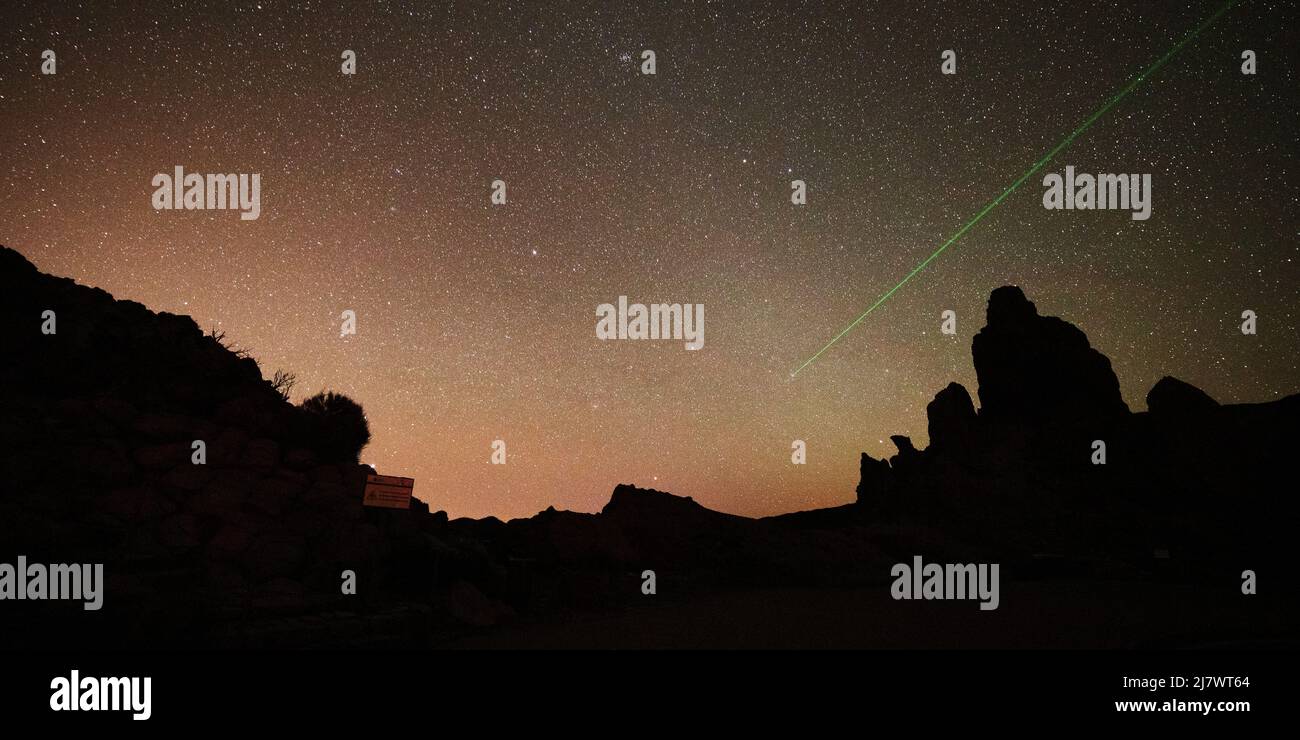 Un raggio laser indica le stelle nel cielo notturno sopra Las Rochas nel Parco Nazionale del Teide a Tenerife, Spagna. Foto Stock