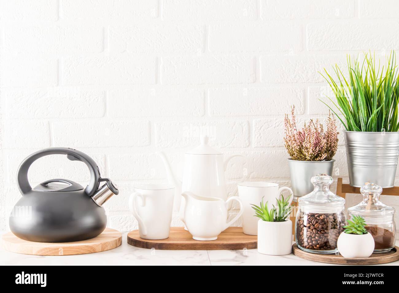 l'interno del piano cucina con bollitore, tazze, caffettiera e varie belle piante in pentole moderne Foto Stock