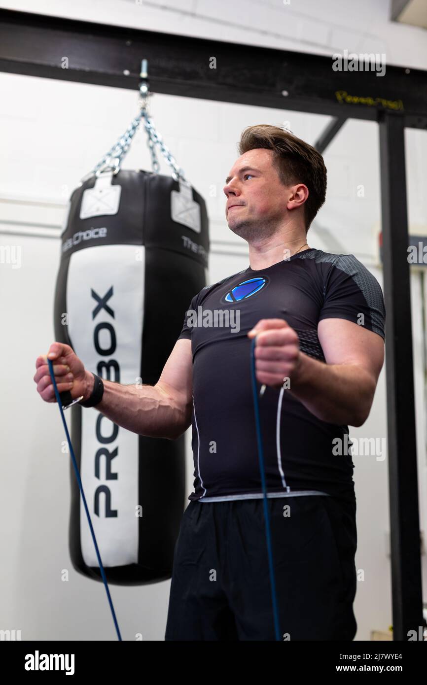 Ipswich Suffolk UK Aprile 03 2022: Un uomo sano e in forma che utilizza bande di resistenza per un allenamento nella parte superiore del corpo Foto Stock