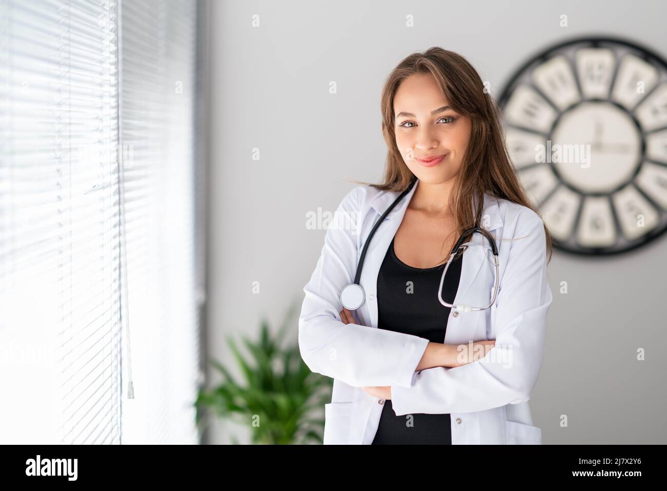 Un medico femminile attraente sta osservando con, fiducia e sorriso grazioso. Foto di alta qualità Foto Stock