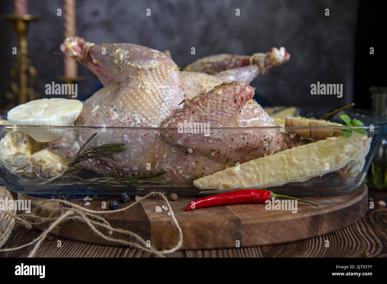 Il pollo crudo marinato in salsa di panna acida è in un vassoio di vetro Foto Stock