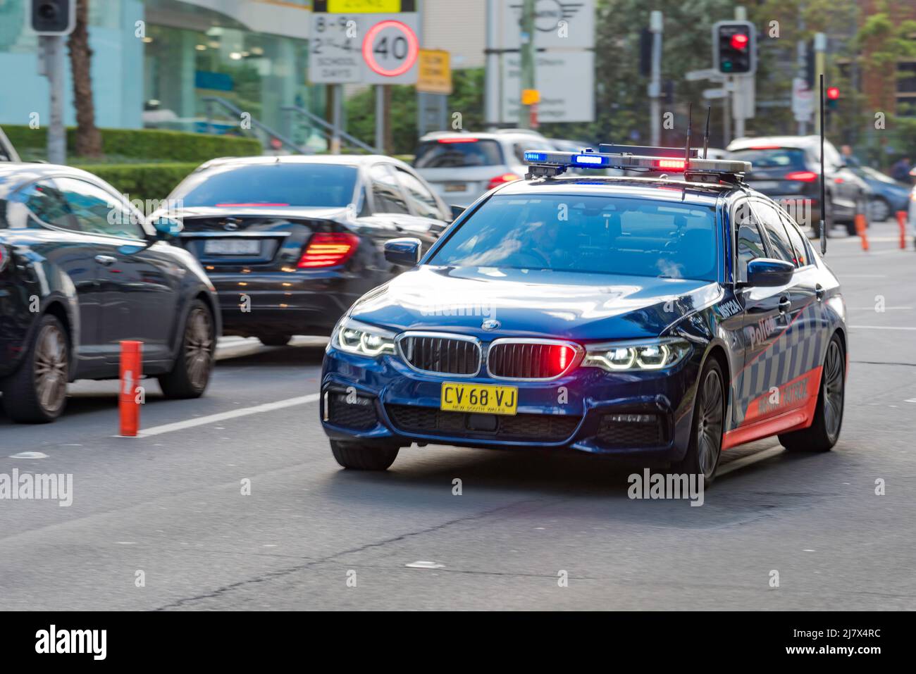 A New South Wales, Highway Patrol, Police inseguimento veicolo con luci accese, viaggiando ad alta velocità in traffico pesante a Sydney, Australia Foto Stock