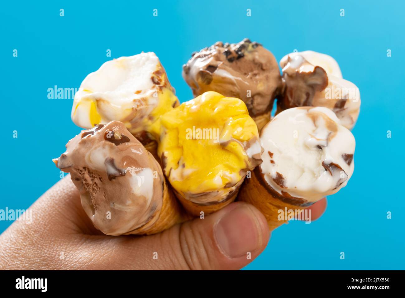 mans mangiare sei mini coni gelato di dimensioni con sapori diversi allo stesso tempo Foto Stock