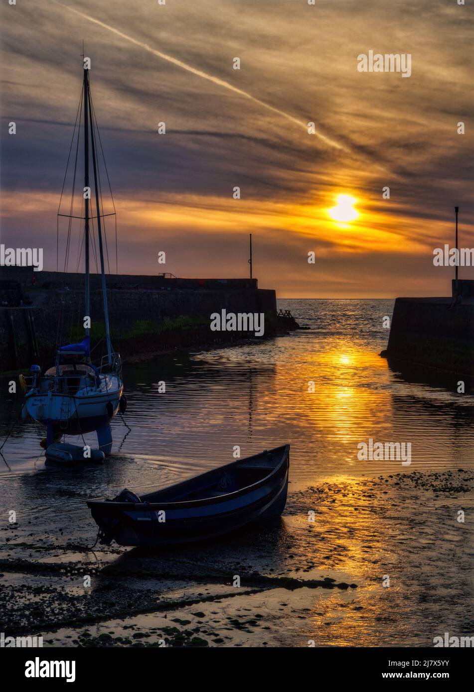 Il sole tramonta tra le mura del porto di Aberaeron, Cardigan Bay, Galles. Foto Stock