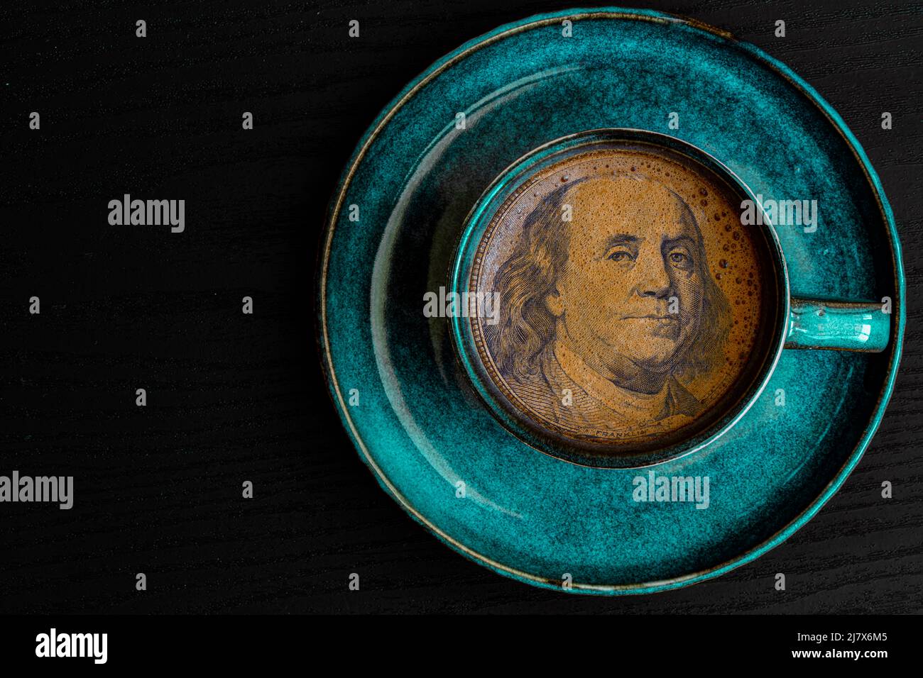 Benjamin Franklin da banconota da 100 dollari in una tazza di caffè a scopo di progettazione Foto Stock