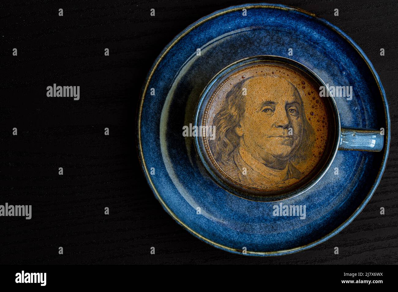 Benjamin Franklin da banconota da 100 dollari in una tazza di caffè a scopo di progettazione Foto Stock